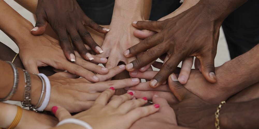 Many hands together: group of people joining hands